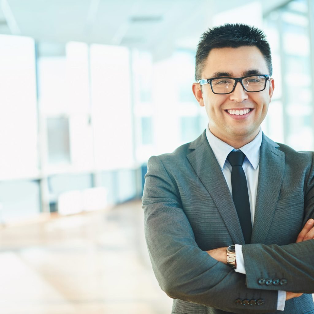 Cheerful businessman in formalwear keeping his arms crossed